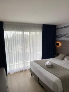 基伯龙欧罗巴酒店的一间卧室设有一张大床和一个大窗户