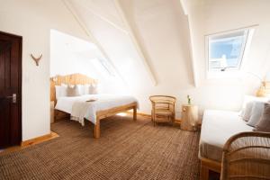 帕特诺斯特Gonana Guesthouse的白色的客房设有两张床和窗户。