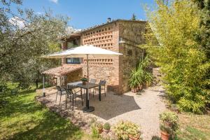 拉迪孔多利Monolocale Antico Fienile的庭院配有遮阳伞和桌椅。