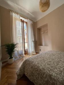 都灵La Petite Maison de la Ville的一间卧室配有一张大床和盆栽植物
