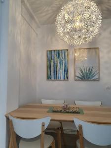 圣地亚哥－德孔波斯特拉AdA Apartamento的一间带桌子和吊灯的用餐室