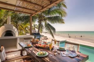 奥尔沃克斯岛Hotel Boutique Casa Muuch Holbox - Solo Adultos的海滩上一张带食物盘的桌子