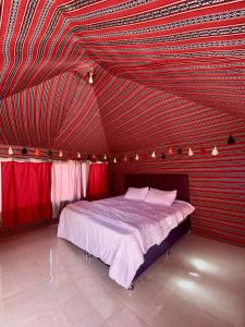 瓦迪拉姆Wadi Rum Silk Road Camp的一间卧室设有一张红色天花板的大床