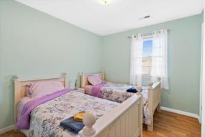 海洋岛海滩Turtle Shack - Ocean Isle Beach -Whole Beach House的一间卧室设有两张床和窗户。