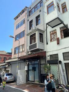 伊斯坦布尔Blue Mansion Hotel & Flats的两个女人在建筑物前的街道上走