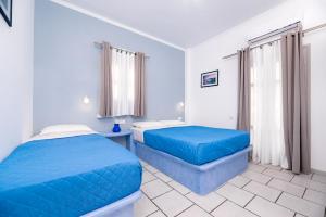 佩里萨Fortuna Perissa的一间卧室配有两张蓝色床单