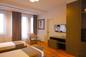 地拉那Mark Hotel Tirana的酒店客房设有两张床和一台平面电视。