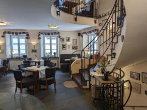 拜尔施泰因科拉佩尔博格酒店的餐厅设有螺旋楼梯和桌椅