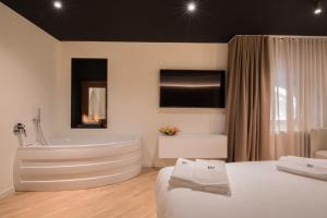 米兰Brera Luxury Apartment near Duomo With Wifi的带浴缸、床和电视的浴室