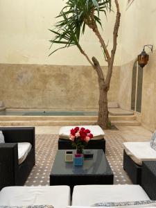 马拉喀什144号摩洛哥传统庭院旅馆的一间棕榈树客房和一张鲜花桌