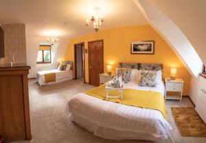 阿卡莱克Innes House Bed & Breakfast的一间卧室设有两张床和黄色的墙壁