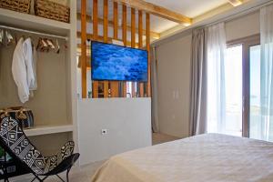 PachainaOcean Pearl Luxurious Suite的一间卧室配有一张床,墙上配有电视