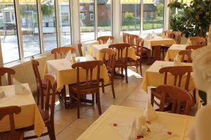 奥斯赛拜-塞林斯林呢尔霍夫酒店的用餐室设有桌椅和窗户。