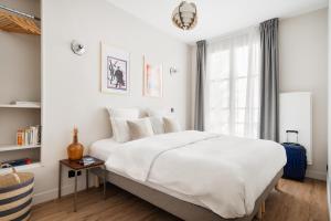 巴黎Edgar Suites Champs Elysées - Boétie的卧室设有一张白色大床和一扇窗户。