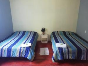 帕克拉Donde Familia Manito的两张睡床彼此相邻,位于一个房间里
