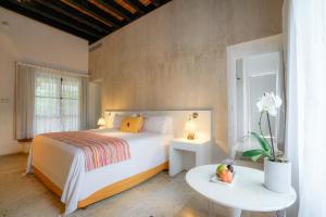 库埃纳瓦卡Anticavilla Hotel Restaurante & Spa的卧室配有白色的床和带桌子的西德克斯桌