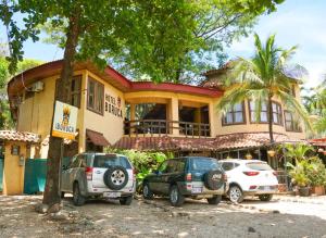 塔马林多Hotel Boruca Tamarindo的前面有车停放的房子