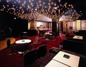黑部市总庙庄园酒店的天花板上设有桌椅和灯的房间