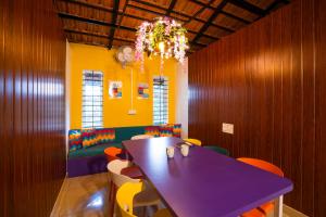 马迪凯里goSTOPS Coorg的色彩缤纷的教室,配有紫色的桌子和椅子