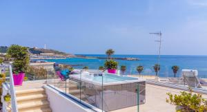 莱乌卡Le Pativite Luxury Apartments by HDSalento的阳台设有游泳池,享有海景。