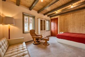 Sulzbach an der MurrRote Wohnung - Goldenes-Häusle的一间卧室配有一张床、一把椅子和一张沙发