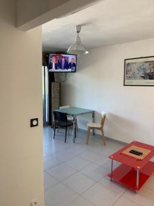 蒙彼利埃Appartement en résidence climatisé avec parking的客厅配有桌子和墙上的电视
