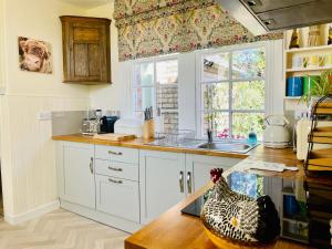 HurlfordCarnell Country Estate的厨房配有白色橱柜和位于柜台上的鸡