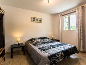 Labastide-de-ViracVilla La Lauze的一间卧室配有一张带两张桌子和一扇窗户的床。