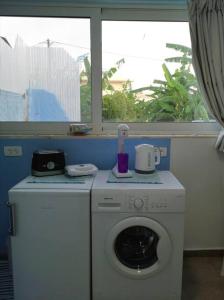 拉多斯Valantas Garden Suite的窗户间里的洗衣机和烘干机