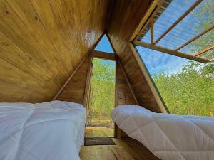 OzurgetʼiDumbo Eco Camp的树屋的卧室,设有大窗户