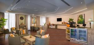 马斯喀特Centara Life Muscat Dunes Hotel的酒店大堂设有桌椅和酒吧