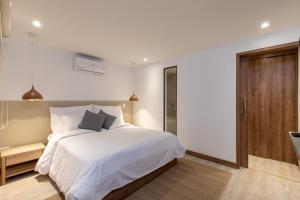 麦德林Villaz Luxury Vacation Homes的卧室配有白色的床和木门