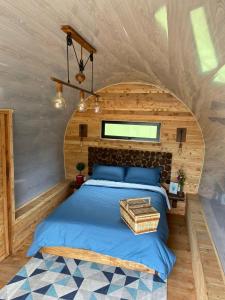 瓜塔佩Glamping La Cepa GUATAPÉ的一间小房子里的卧室,配有床