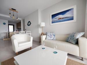 贝尼多姆SUNSET WAVES sea & sky apartment的客厅配有白色的沙发和椅子