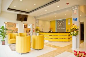 塔克纳Mercé Hotel的一个带黄色椅子和柜台的商店大堂