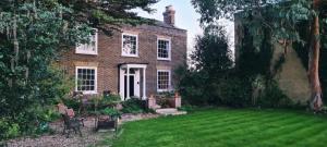 切森特Manor House of Cheshunt- Historic Villa的一座带草坪的庭院的大型砖屋