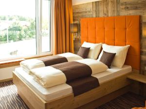 布赫洛厄阿尔本弗莱酒店的一间卧室设有一张大床和大窗户