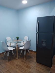 圣地亚哥洛斯卡巴Paulino的用餐室配有桌子和黑冰箱