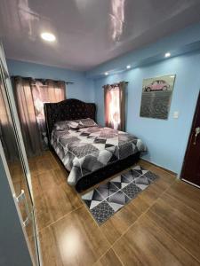 圣地亚哥洛斯卡巴Paulino的一间设有床铺的卧室,位于一间拥有蓝色墙壁的房间