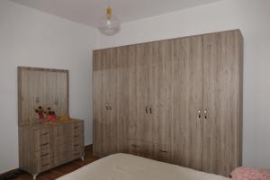 都拉斯Villa Panorama的一间卧室配有木制橱柜、一张床和一个梳妆台
