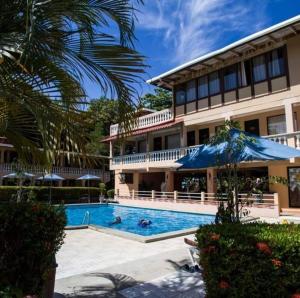 塔尔科莱斯House of the Macaws的大楼前设有游泳池的酒店