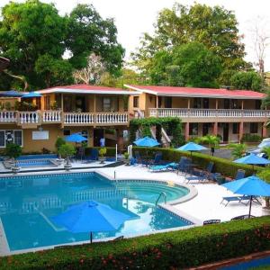 塔尔科莱斯House of the Macaws的酒店设有带遮阳伞的游泳池