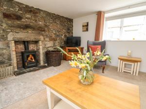 阿伯丁Storkery Cottage的客厅设有壁炉和花瓶。