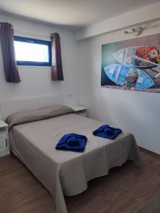 塞博河畔卡莱塔APARTAMENTO LA SAMA的一间卧室配有一张带2条蓝色毛巾的床