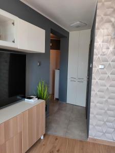 科沃布热格Apartament Nadmorski的厨房配有白色橱柜和平面电视。