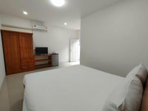 美索King Fa House的卧室配有白色的床和木制橱柜。
