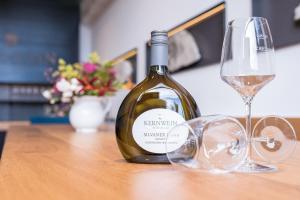 SeinsheimWeingut Kernwein的桌子上放有一瓶葡萄酒和两杯酒