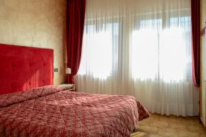阿塞尔吉菲奥尔蒂格吉里酒店的一间卧室设有红色的床和2个窗户。