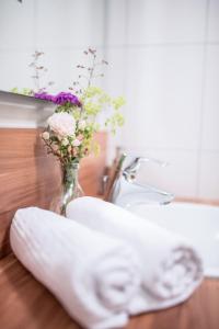 SeinsheimWeingut Kernwein的毛巾坐在带花瓶的浴室台上