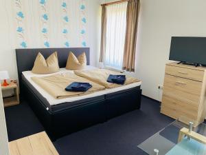 博伊岑堡Waldhotel的一间卧室配有一张带2条蓝色毛巾的床